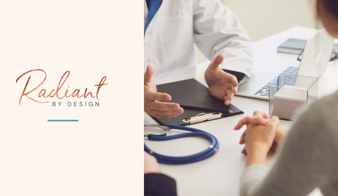 A doctor in a white coat gestures across a desk with a clipboard and stethoscope while a client sits with clasped hands.
