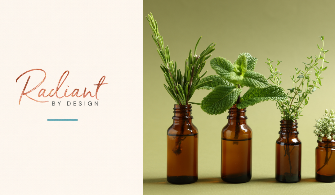 Sprigs of rosemary, mint, thyme and a small white flower stand in four amber bottles on a soft green background.