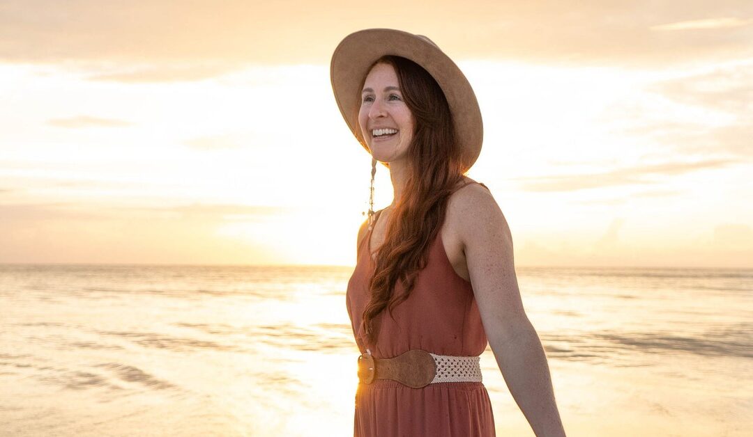 Kate Vazquez smiling on the beach at sunrise