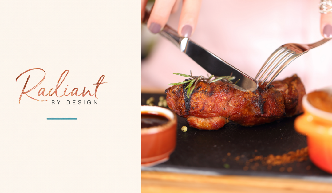 A hand with a knife and fork cuts into a seared steak topped with rosemary, beside small dishes of sauce on a slate board.